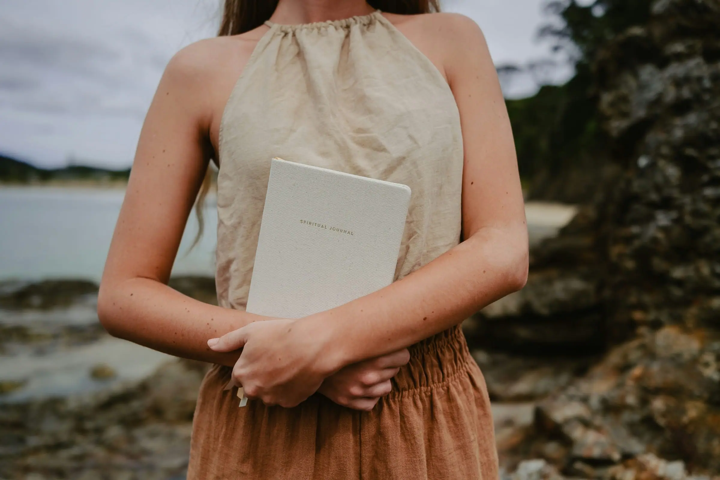 A notebook beside a quiet coastal view during a personal pause