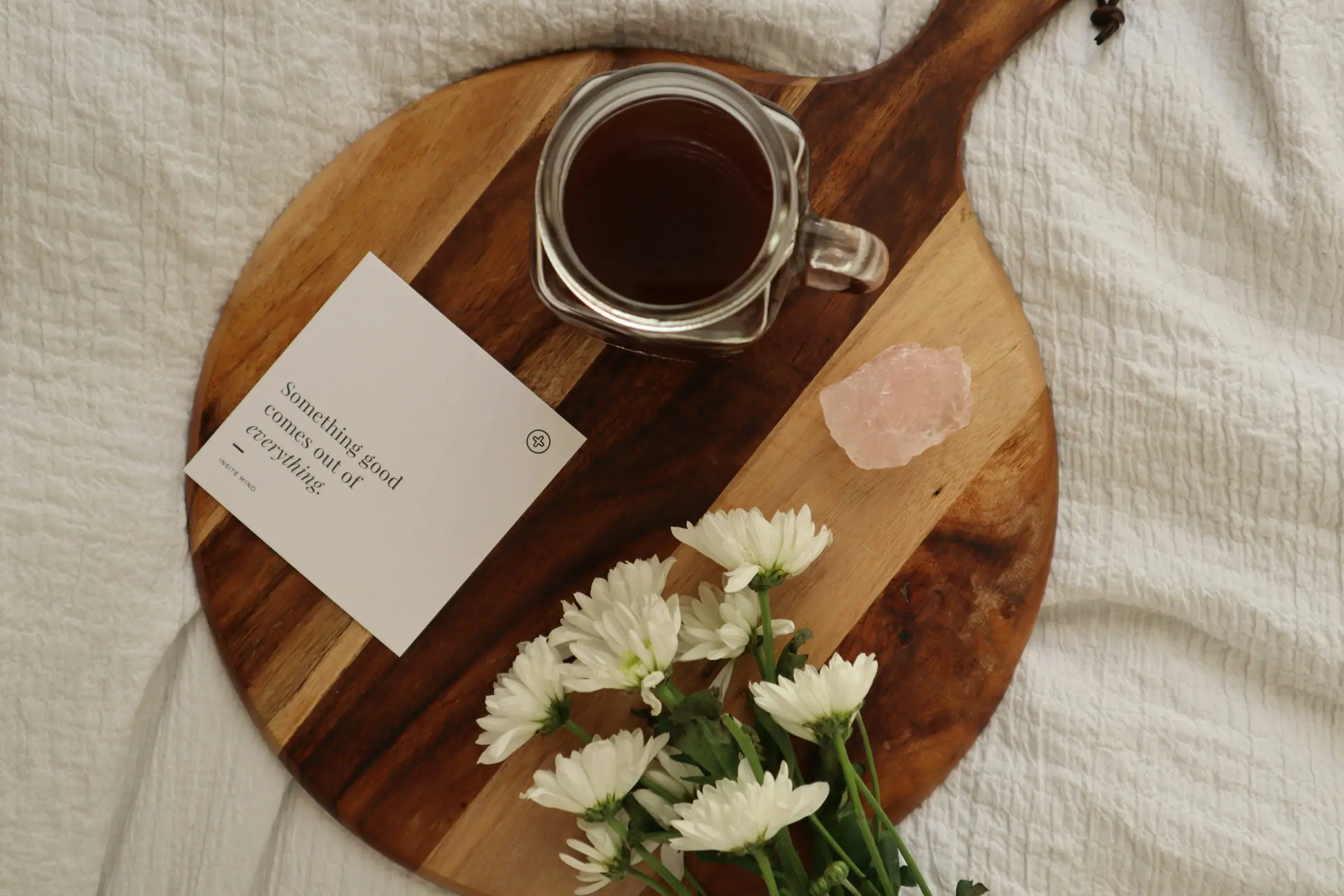 Coffee, flowers and a book arranged for a slow Sunday at home