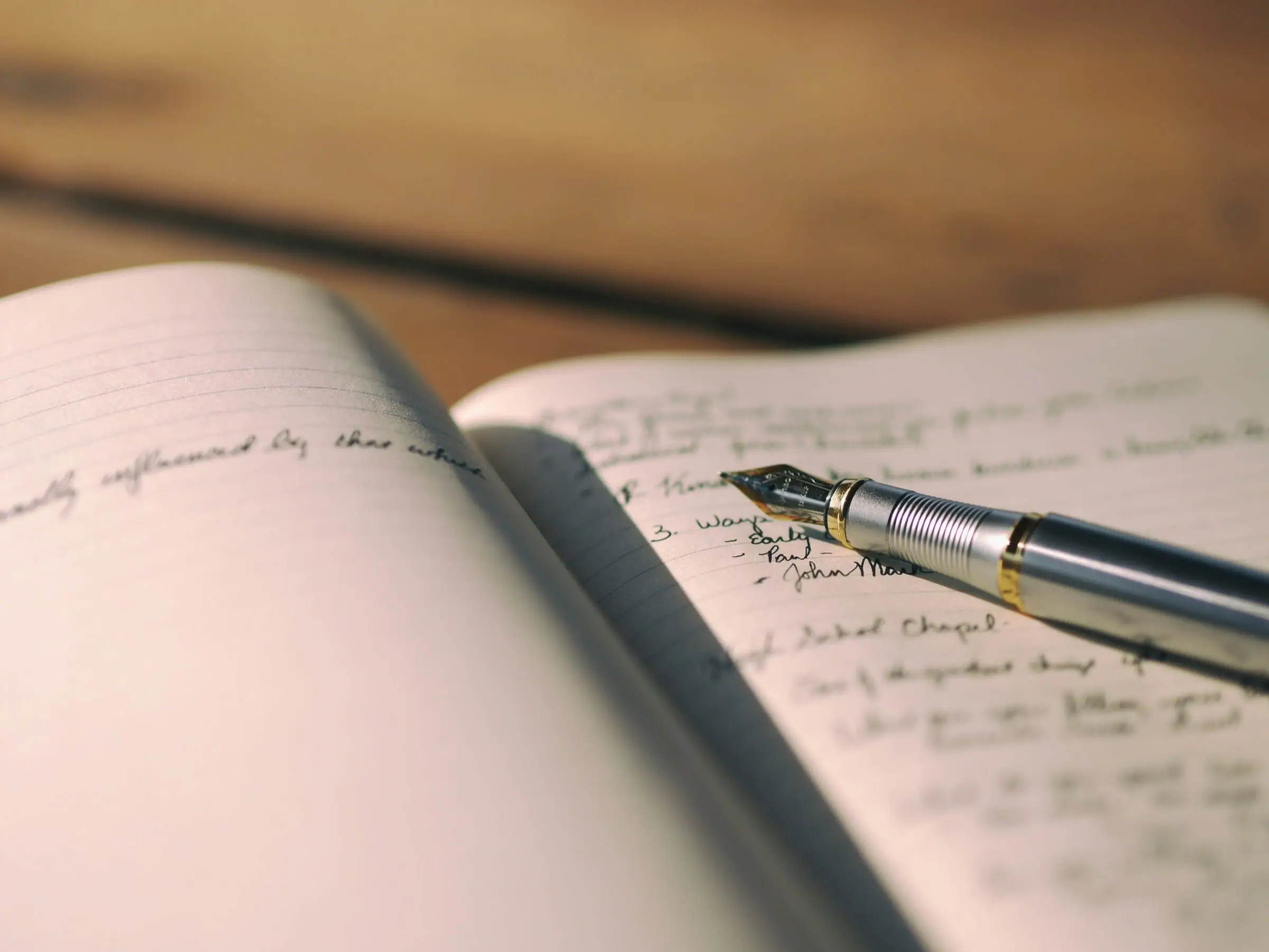 An open handwritten journal and pen