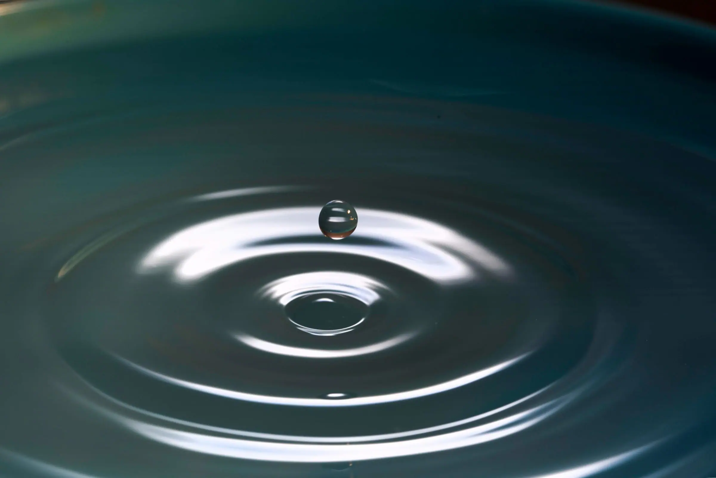 A water droplet creating soft ripples for a simple bath ritual